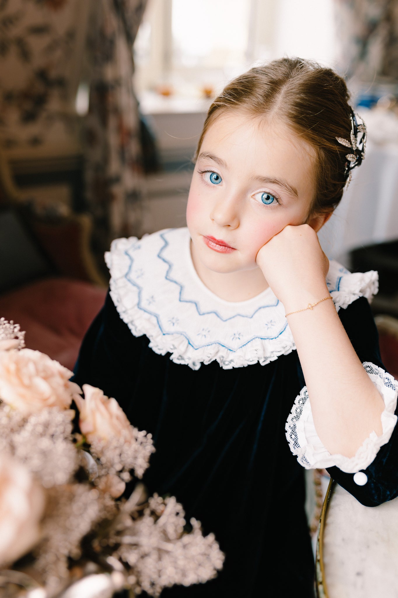 Close-up of young girl wearing Celeste Navy Velvet Long Sleeve Bishop Dress