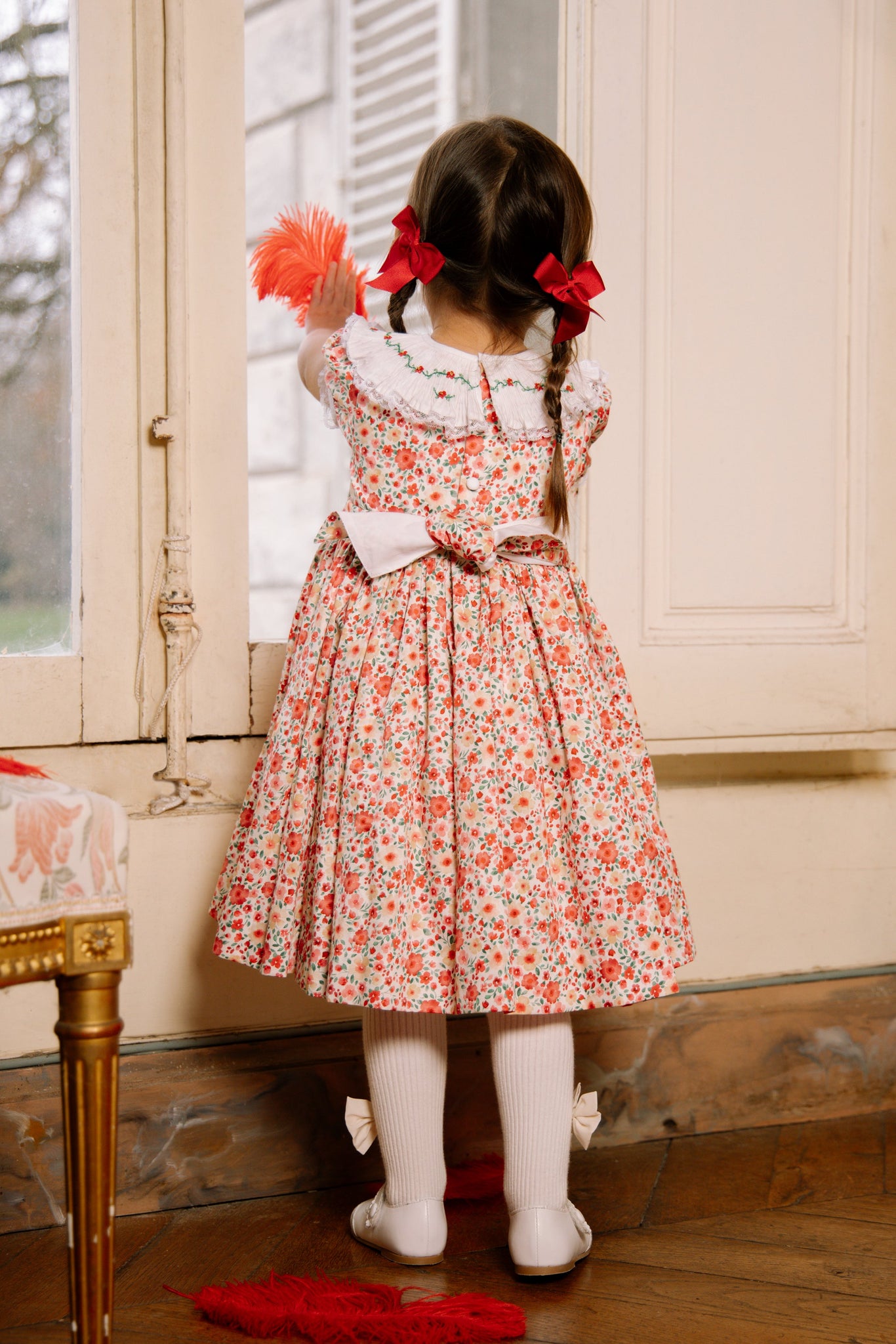 Back of young girl wearing Celestine Red Floral Smocked Dress