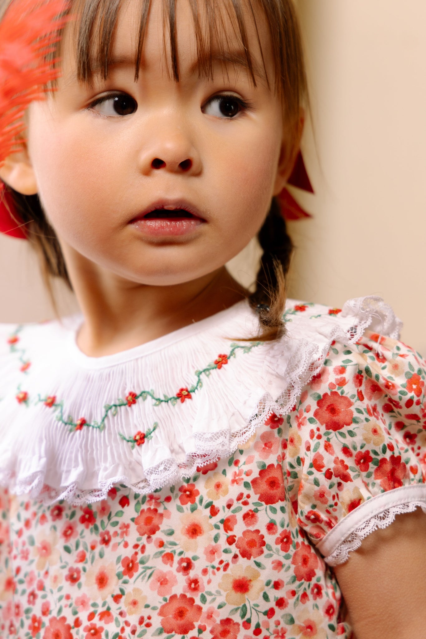 Close-up of young girl wearing Celestine Red Floral Smocked Dress