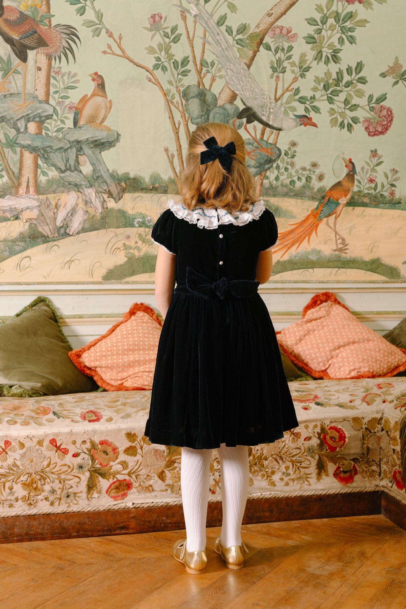 Back of young girl wearing Celestine Navy Velvet Smocked Dress